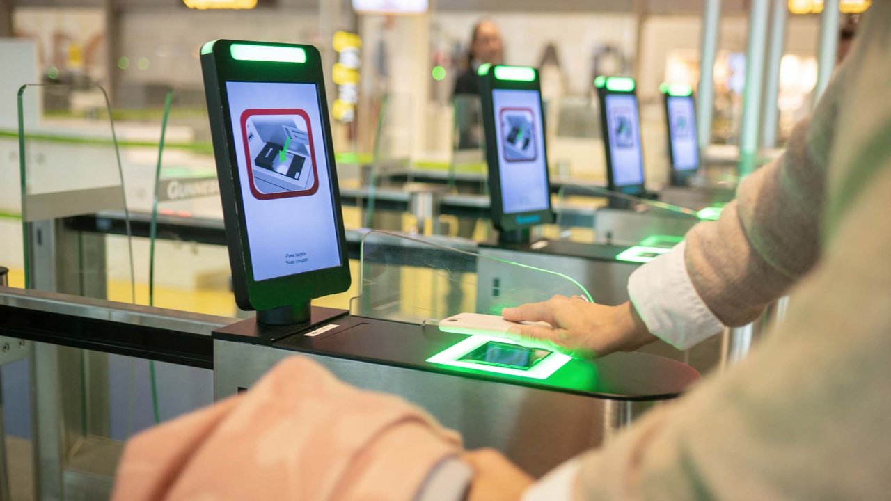 Havalimanında otomatik pasaport kontrol kapısından geçen yolcu.