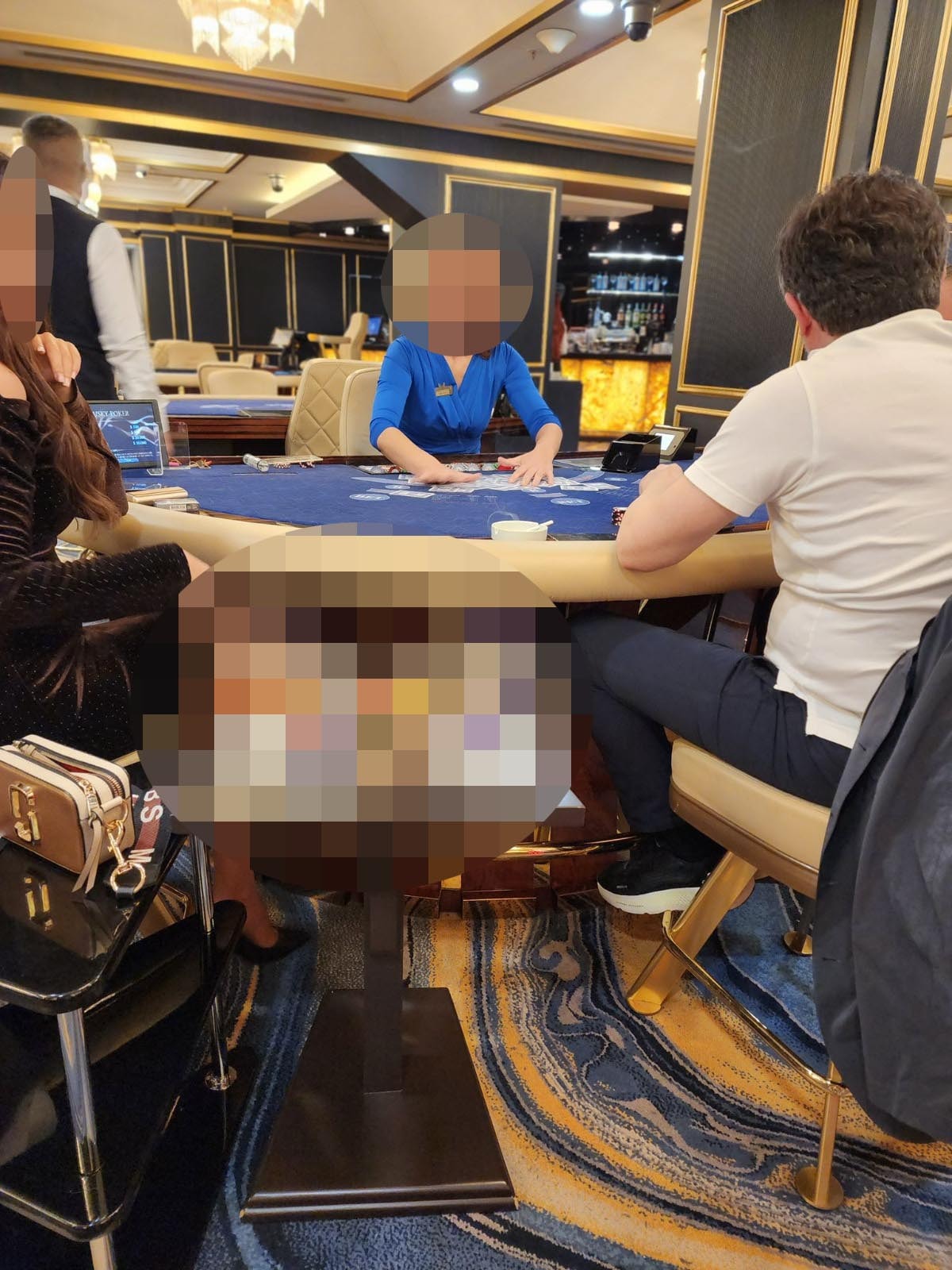Photo showing a dealer and people sitting at a casino table.
