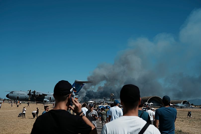 Crowd watching smoke rise after the fighter jet crashed at the Tanagra Airport air show area.