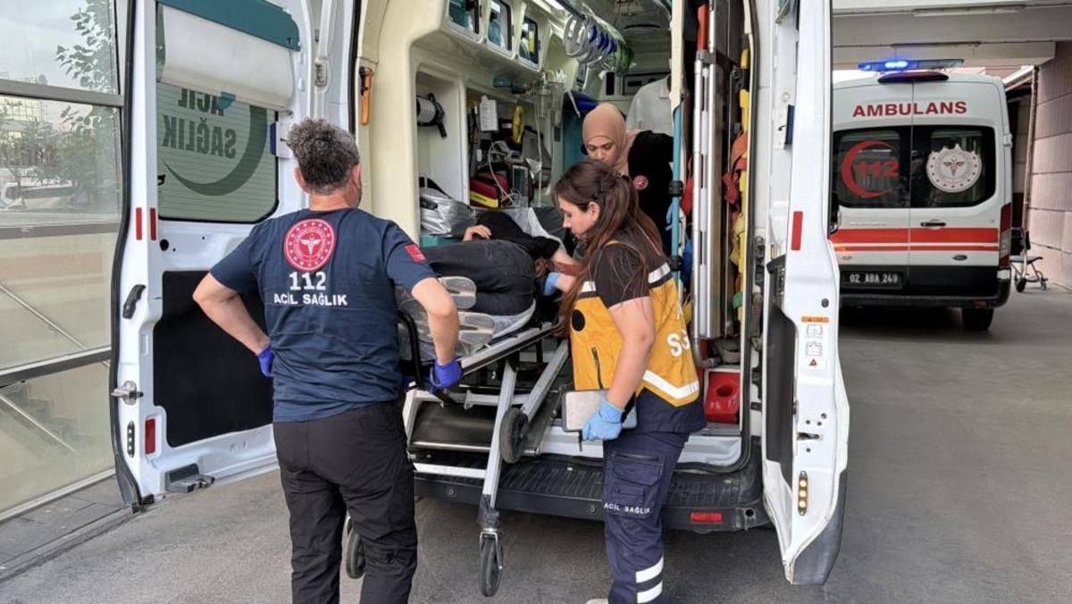 Ambulans yanında sağlık ekiplerinin sedyedeki yaralıya müdahale ettiği görüntü.