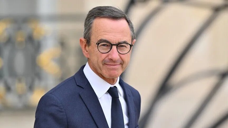 A portrait photo of Bruno Retailleau in a suit taken outdoors.