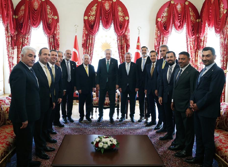 Le président Recep Tayyip Erdoğan pose avec la délégation de Fenerbahçe dans une salle.